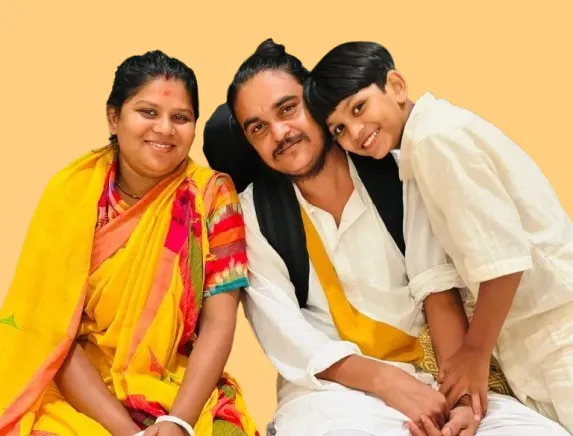 സുമന്ത ദാസ് ബൗളും കുടുംബവും ഒന്നിച്ച് ഇരിക്കുന്നു, ഒരാൾ തന്ത്രിവാദ്യം പിടിച്ചിരിക്കുന്നു.